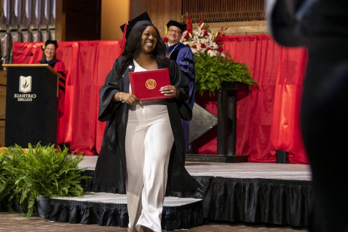 A 2023 Carthage College graduate beams as she leaves the Commencement stage after receiving her d...